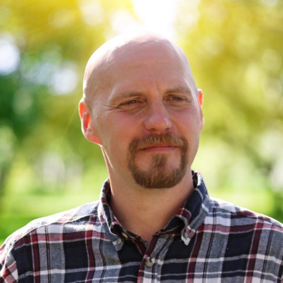 Joel, leende utomhus mot grönska